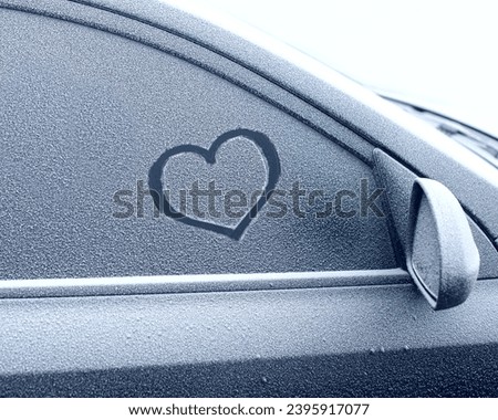 heart symbol on frozen car window in winter