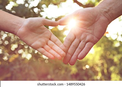 Herzsymbol bei Sonnenuntergang. Vater mit Kind, das Händchen hält