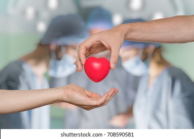 Heart transplant and organ donation concept. Hand is giving red heart. - Shutterstock ID 708590581
