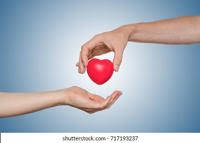 Heart Transplant And Organ Donation Concept. Hand Is Giving Red Heart.