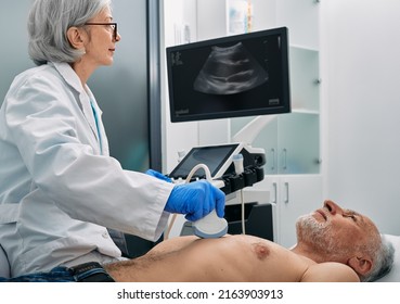 Heart Ultrasound Exam For Senior Man With Ultrasound Specialist While Medical Exam. Heart Health Exam With Ultrasound Scan Machine