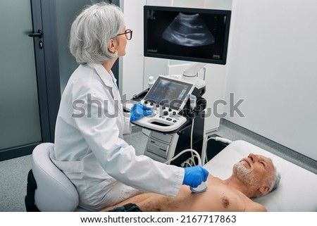 Heart ultrasound exam for senior man with ultrasound specialist while medical exam at hospital