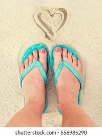 Heart And Woman Feet Wearing Flip Flops In The Sand Of A Beach, Vintage Process