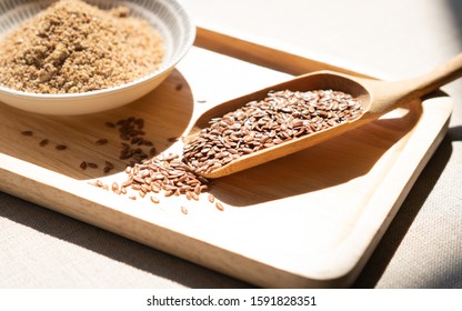 Heart-healthy food - Close up of flaxseeds or linseeds in a wooden tea spoon with a pile of ground flaxseeds. Omega-3 fatty acid ALA, Lignans, Fiber, Antioxidant, Cardiovascular, Weight loss, diabetes