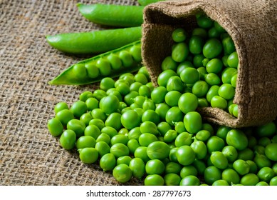 hearthy fresh green peas and pods on rustic fabric background