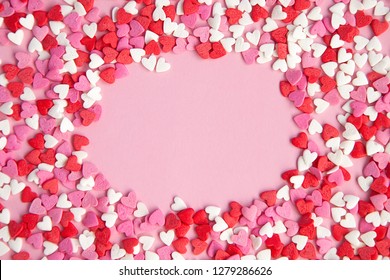 hearts background from many sugar mini red and pink hearts. Blank center for text