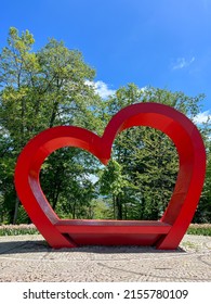 hearts, big red heart over green trees and beautiful blue sky in a sunny day at a park in spring or summer with copy space.
