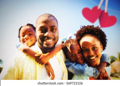 Hearts hanging on a line against couple posing together with their children at park - Shutterstock ID 569721526