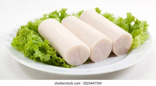 hearts of palm rolls over lettuce in plate on white background.