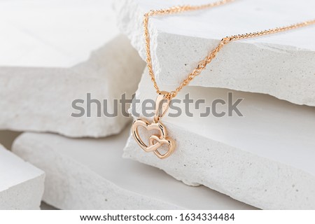 Hearts shape rose gold pendant necklace on white background. Romantic  jewelry. Advertising still life product concept for Valentines Day