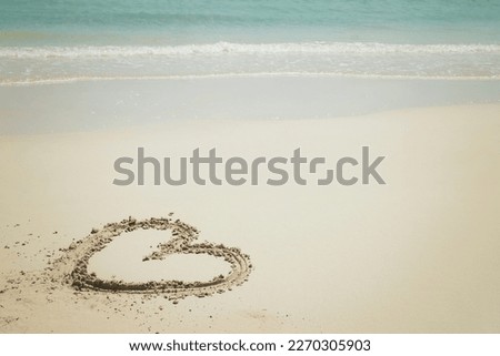 Heart-shaped beach with bright blue water.