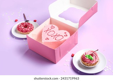 Heart-shaped bento cake with donut and cupcake on purple background. Valentine's Day celebration - Powered by Shutterstock