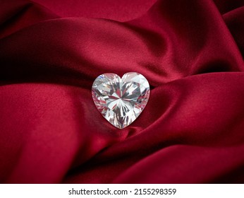 Heart-Shaped Diamond on Red Silk Background. Heart Cut Solitaire Diamond.