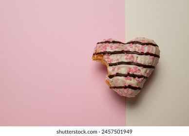 A heart-shaped donut with pink icing and chocolate sprinkles. Th - Powered by Shutterstock