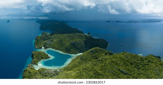 A heart-shaped lagoon is surrounded by dramatic limestone islands that rise from Raja Ampat's seascape in Misool. This remote part of Indonesia is known for its incredible marine biodiversity.