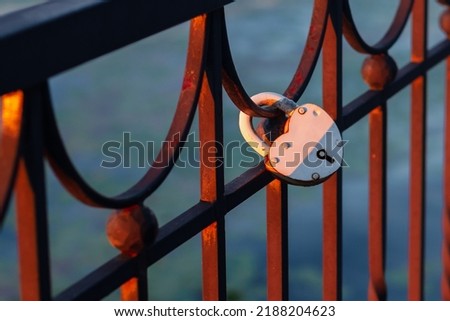 Heart-shaped locks hang on the fence on the river embankment as a sign of love and loyalty for a wedding.