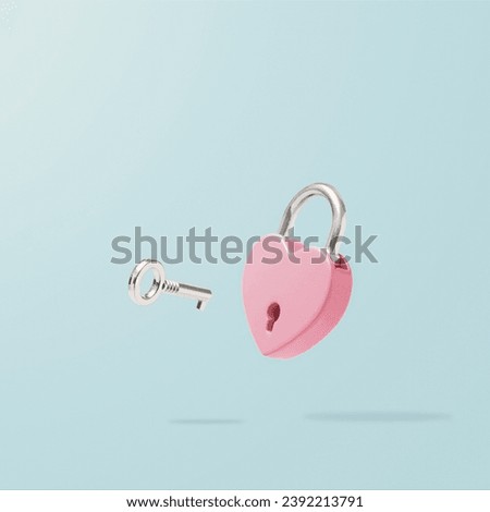 Heart-shaped pink padlock with  flying key on pastel blue background. Minimal Valentines Day, wedding or Mother's day concept. Creative love romantic emotion composition. Love messages for couples.