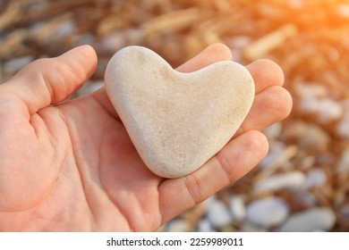 a heart-shaped stone rests on arm - Powered by Shutterstock