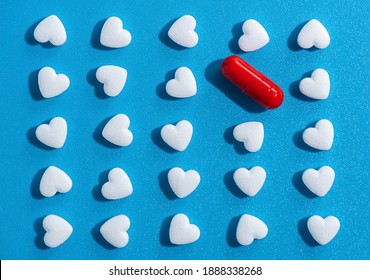 Heart-shaped Tablets And Red Pill. Pattern On Blue Background. Medicine, Cardiology, Health. Top View, Flat Lay