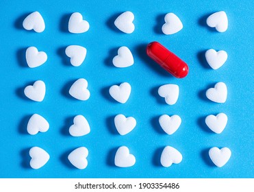 Heart-shaped Tablets And Red Pill. Pattern On Blue Background. Medicine, Cardiology, Health. Top View, Flat Lay