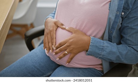 Heartwarming moment, young successful pregnant businesswoman at office, forming a heart gesture with her hands over belly, embracing upcoming motherhood indoors - Powered by Shutterstock