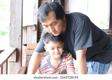 A heartwarming scene of a father and son enjoying quality time together, showcasing their affection and playful interaction in a cozy indoor setting. - Powered by Shutterstock