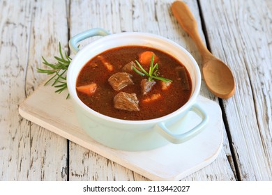 hearty homemade goulash soup on a wooden table - Shutterstock ID 2113442027