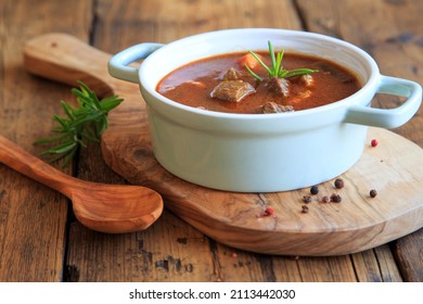 hearty homemade goulash soup on a wooden table - Shutterstock ID 2113442030