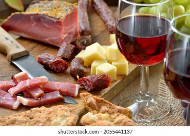 Hearty snack in South Tyrol with the typical bacon, salami, mountain cheese and the very crunchy flat rye bread, so-called Schuettelbrot, served with a good local red wine