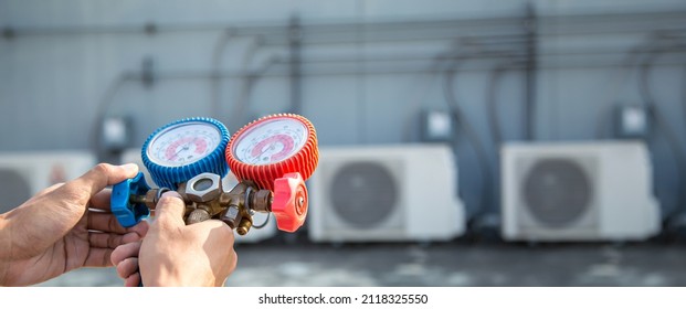 Heat And Air Conditioning, HVAC System Service Technician Using Measuring Manifold Gauge Checking Refrigerant And Filling Industrial Air Conditioner After Duct Cleaning Maintenance Outdoor Compressor.