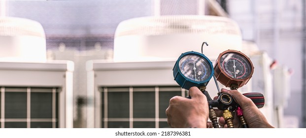 Heat And Air Conditioning, HVAC System Service Technician Using Measuring Manifold Gauge Checking Refrigerant And Filling Industrial Air Conditioner After Duct Cleaning Maintenance Outdoor Compressor.