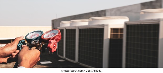 Heat And Air Conditioning, HVAC System Service Technician Using Measuring Manifold Gauge Checking Refrigerant And Filling Industrial Air Conditioner After Duct Cleaning Maintenance Outdoor Compressor.