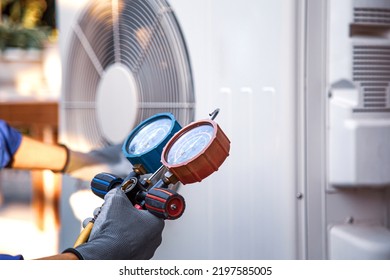 Heat And Air Conditioning, HVAC System Service Technician Using Measuring Manifold Gauge Checking Refrigerant And Filling Industrial Air Conditioner After Duct Cleaning Maintenance Outdoor Compressor.