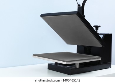 Heat Press Machine On Table Against Light Background