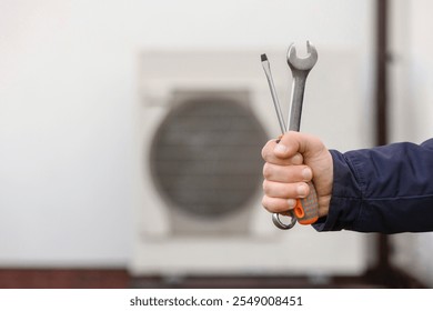 Heat Pump Installing or Fixing by Worker in front of Building. Modern Heat Pump Maintenance and Services. - Powered by Shutterstock