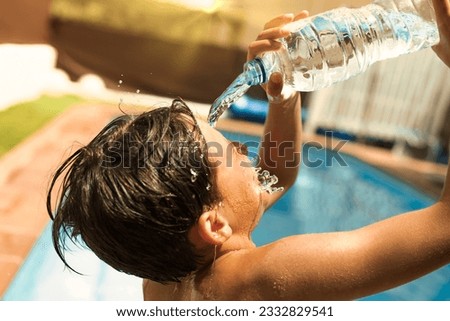 Heat wave in summer due to high temperatures that can cause heat stroke in people. Person hydrating with water due to a heat wave in front of the sun due to the high temperatures of the thermometer