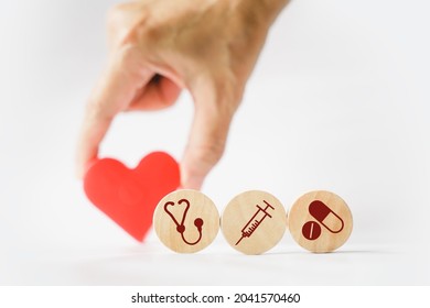 Heath And Medical Icon On Small Round Wood And Blurred Hand Holding Red Heart, Wellness, Wellbeing, Health And Medical, Health Insurance Concept