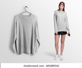 Heather Grey Pullover, Long Sleeve T-shirt On A Young Woman In Skirt, Holding A Smartphone Isolated, Mockup. Pullover, Hoodie Mockup On Hanger, Hanging Against Empty Wall Background.