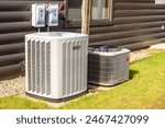 Heating and air conditioning system external units on grass in a house backyard