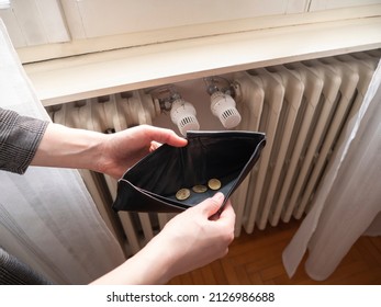 Heating bill. Increase in the cost of gas bill. Soaring energy prices. Increase in the price of natural gas. Energy crisis in Europe. Hands hold wallet with money near the radiator. Pay the bills. - Shutterstock ID 2126986688