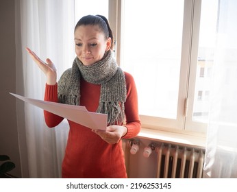 Heating Bill. Increase In The Cost Of Gas Bill. Soaring Energy Prices. Increase In The Price Of Natural Gas. Energy Crisis In Europe. Person Holds Heating Bills In Hand Near The Radiator. 