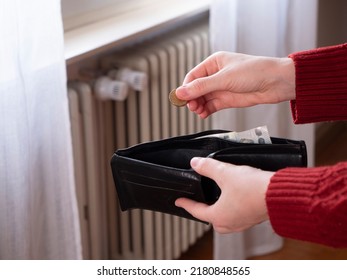 Heating bill. Soaring energy prices. Increase in the price of natural gas. Energy crisis in Europe. Poverty, hand holds money in front of the radiator. Home warming.