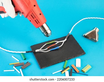 heating with a building hair dryer of heat-shrinkable tubes on the twists of electrical wires - Shutterstock ID 2206007233