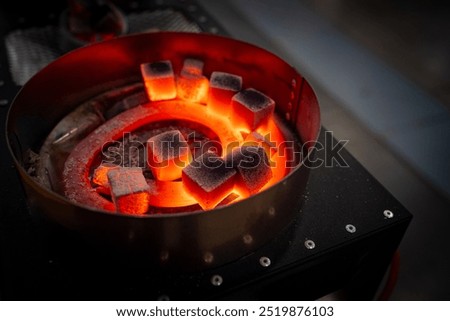 Heating coals for hookah. Preparing to make calabash. Red-hot spiral heats coals from hookah. Equipment for smokers. Stove for heating coal cubes. Professional equipment for hookah bar