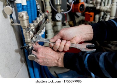 Heating Engineer Installing Modern Heating System In Boiler Room.