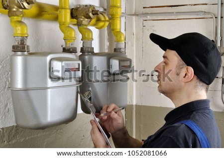 Heating fitter checks gas consumption at gas pipe and meter counter