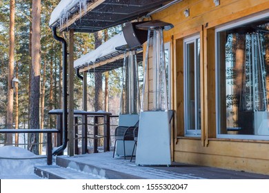 Heating Lamp Placed Among The Tables Of An Open Cafe In Winter During The Day.stainless Steel Metal Gas Heater For Patio.High Outdoor Gas Heater On The Open Terrace Of The Cafe, Home Or Restaurant