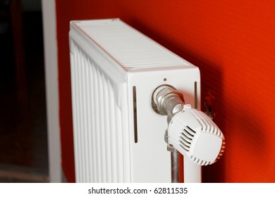 Heating radiator in a room with red wall, shallow focus