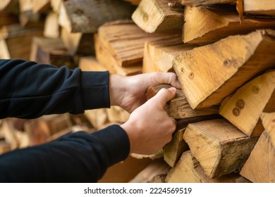 Heating season. Firewood.hands pulling a log from a woodshed. Male hands pulling a log from a woodshed.Heating season in Europe.Firewood and mens hands close-up.  - Powered by Shutterstock