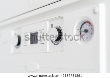 heating system with gas boiler in apartment, control panel with knob buttons, display with temperature indicator and pressure measuring, closeup